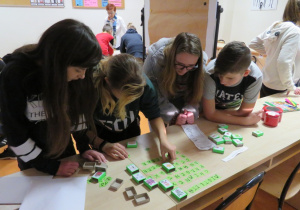 Uczniowie układają z literek ukrytych w pudełkach po zapałkach wyrazy związane ze świętami.