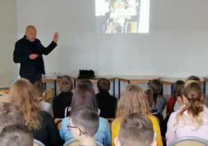Na zdjęciu Andrzej Kalinowski; przedstawia zgromadzonej młodzieży prezentację.